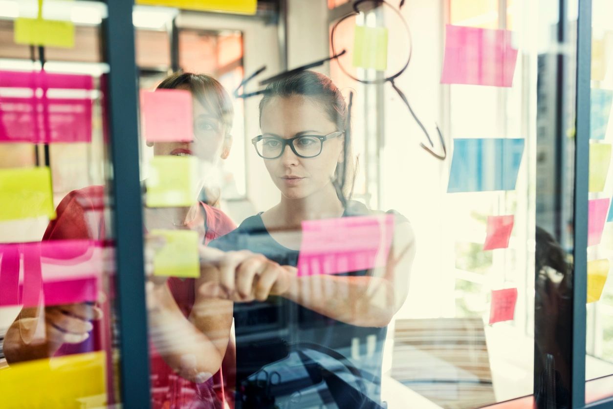 Image of a female office worker, putting notice on a board